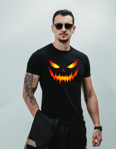 Koszulka na Halloween z przerażającą twarzą dyni, świecącymi oczami i ostrymi zębami w ognistych kolorach